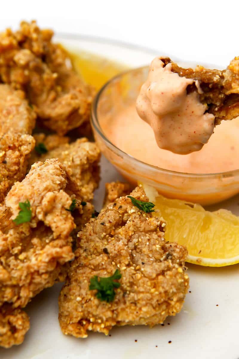 Crispy oyster mushroom chick'n fingers with dipping sauce and lemon
